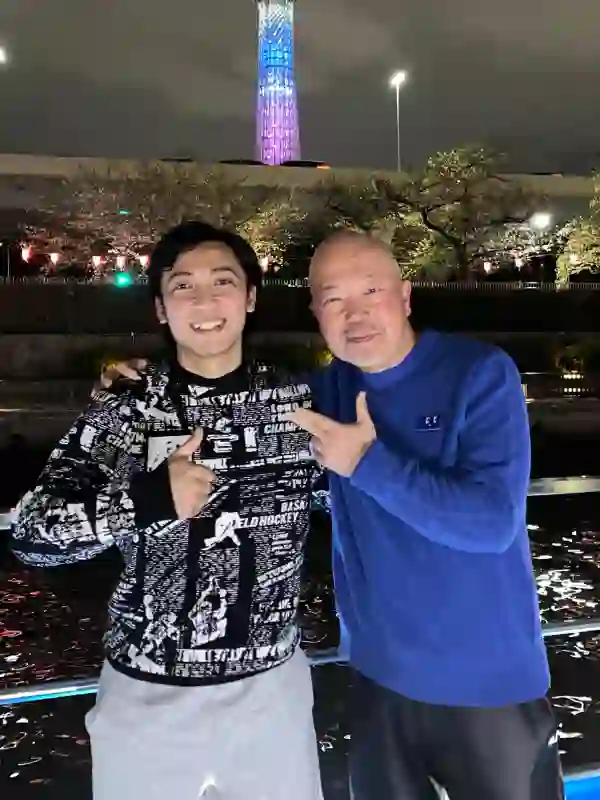 東京スカイツリーを背景に、日本の指導者と笑顔を交わすインドネシア人技能実習生