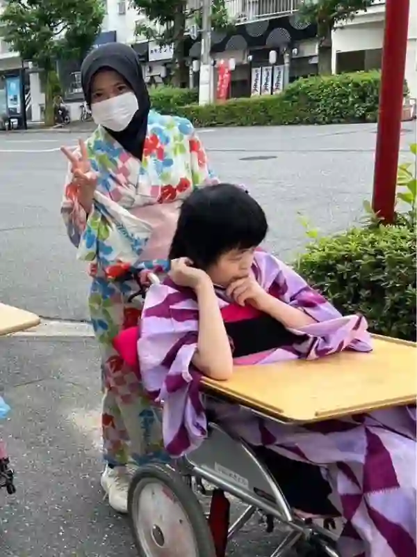 夏祭りの浴衣姿で、利用者の方に寄り添うインドネシア人介護職員
